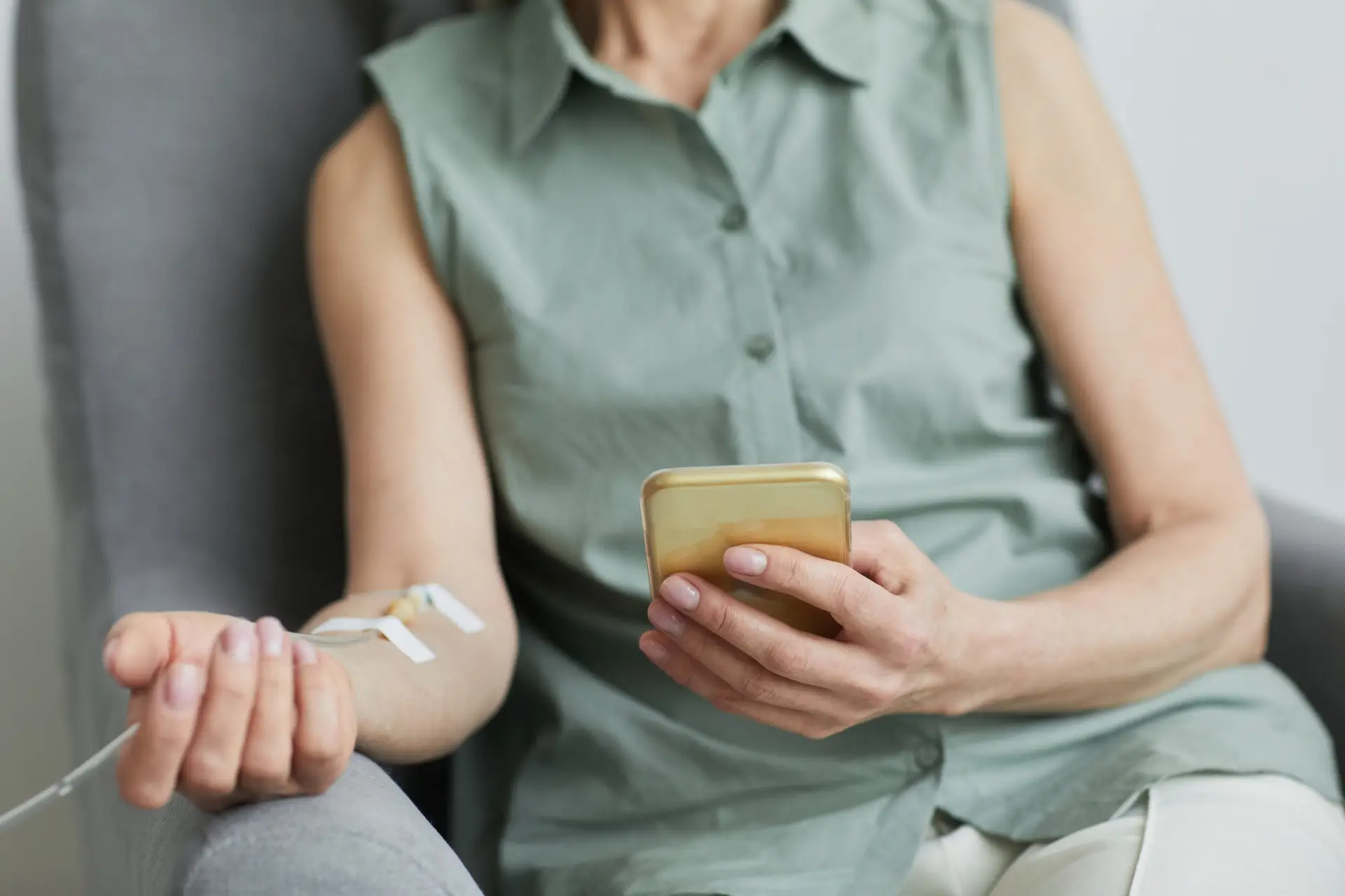 Eine Frau sitzt entspannt im Sessel und erhält eine Vitamininfusion